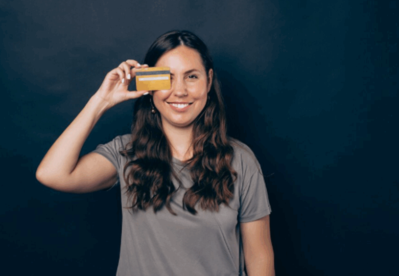 A woman holding a credit card.